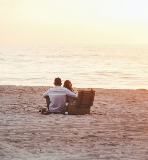 couple-at-beach-near-cooler-1038342